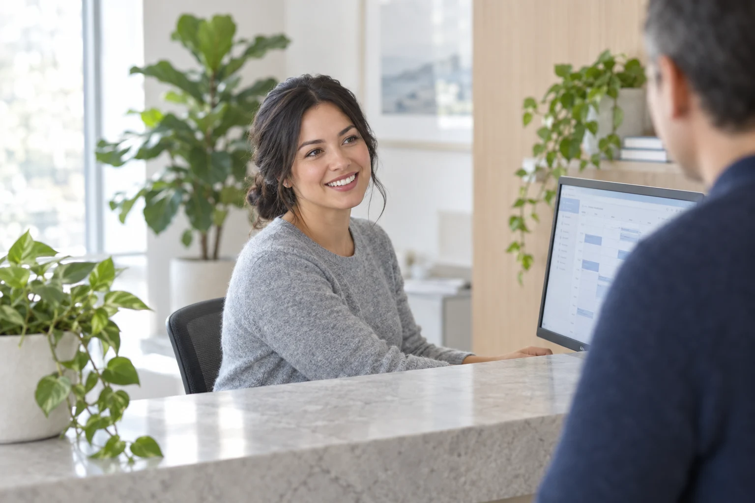A bright dental clinic reception with a tablet showing a booking screen